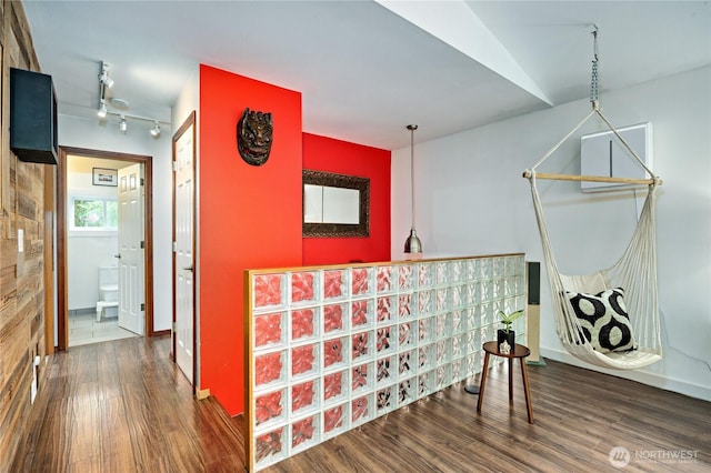 hallway with rail lighting, baseboards, and wood finished floors