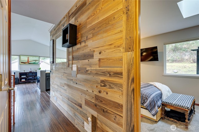 hallway featuring lofted ceiling with skylight and dark wood-style floors