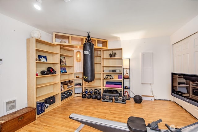 exercise room with visible vents and wood finished floors