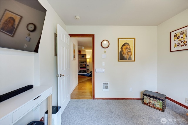 corridor with visible vents, baseboards, and carpet floors