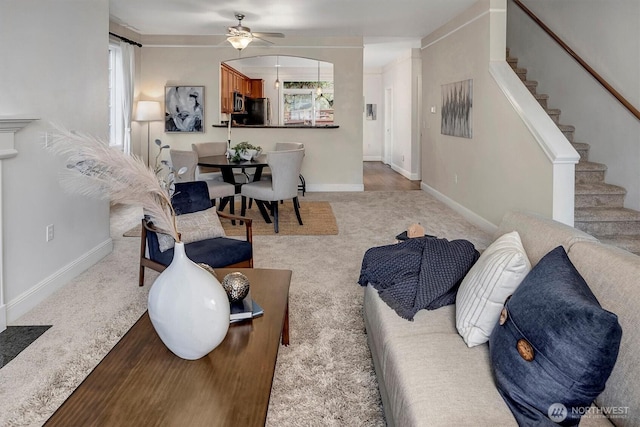 living room with stairs, carpet, and baseboards