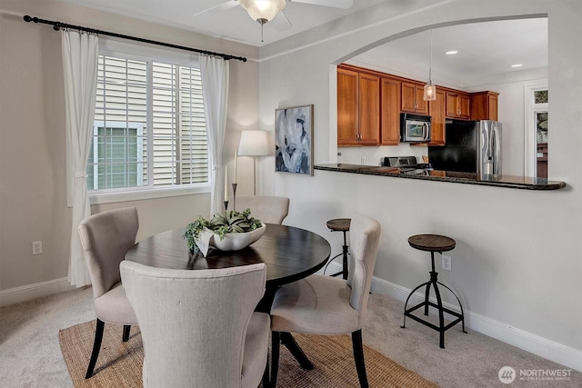 dining room featuring baseboards, recessed lighting, arched walkways, ceiling fan, and light carpet