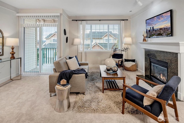 carpeted living area featuring baseboards and a high end fireplace