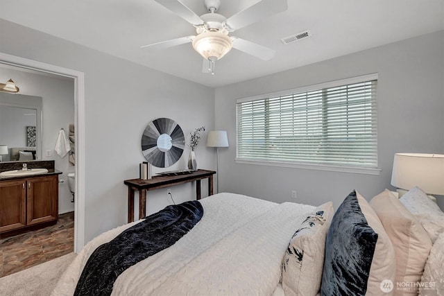 bedroom featuring a ceiling fan, visible vents, and a sink