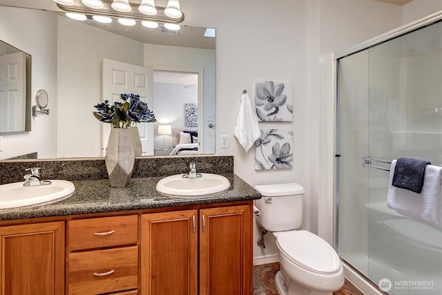 ensuite bathroom featuring a shower stall, toilet, ensuite bathroom, and a sink