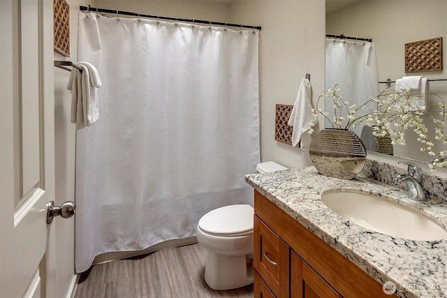 full bathroom with toilet, wood finished floors, and vanity