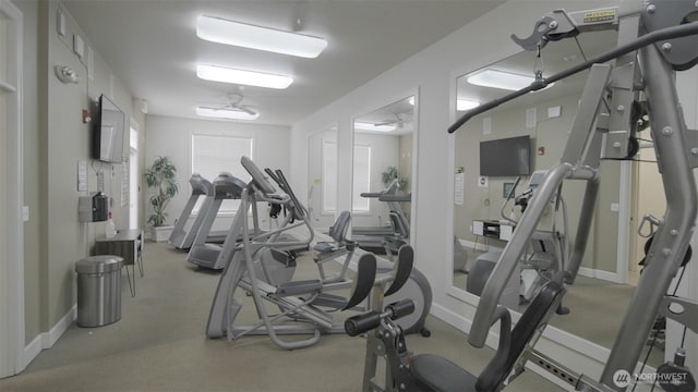 gym with baseboards and a ceiling fan