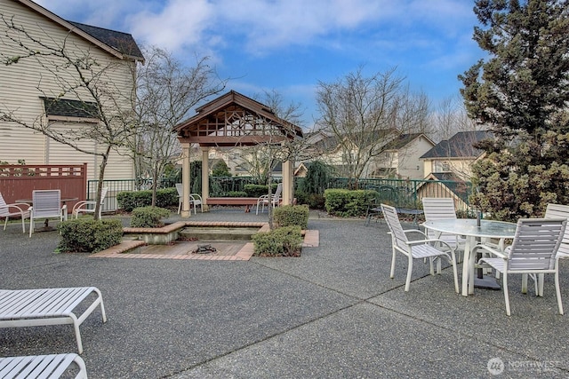 view of patio / terrace featuring a gazebo, outdoor dining space, and fence