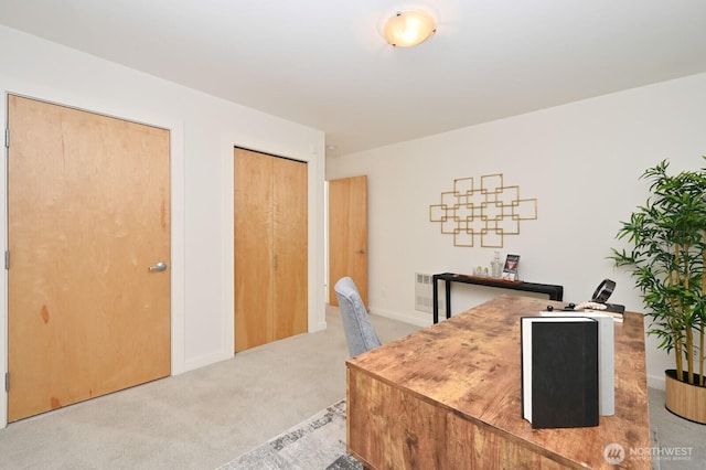 office featuring light carpet, visible vents, and baseboards