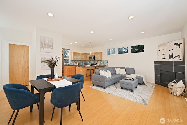 dining space featuring recessed lighting, a fireplace, and light wood-type flooring