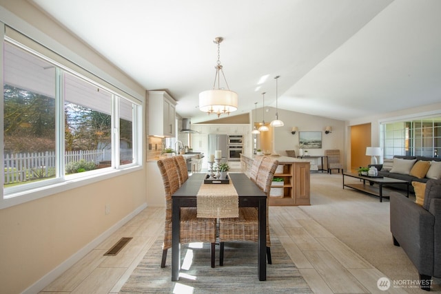 dining space with visible vents, baseboards, and vaulted ceiling