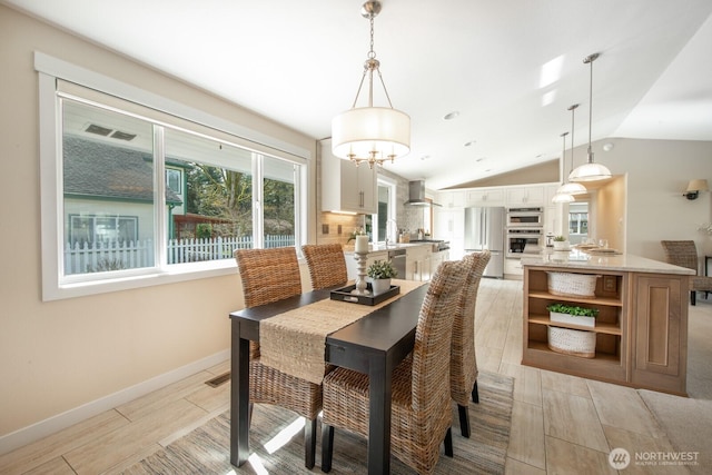 dining room featuring visible vents, wood finish floors, baseboards, a chandelier, and lofted ceiling