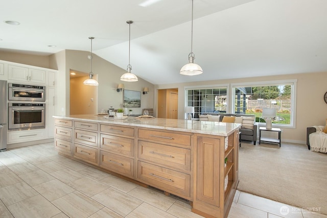 kitchen with decorative light fixtures, open floor plan, a center island, stainless steel appliances, and lofted ceiling