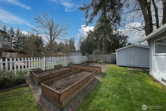 view of yard featuring an outdoor structure, a vegetable garden, fence, and a shed