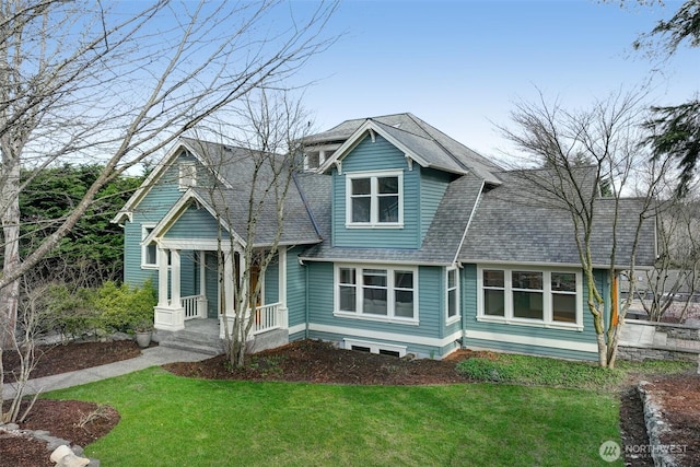 view of front of home featuring a shingled roof and a front yard