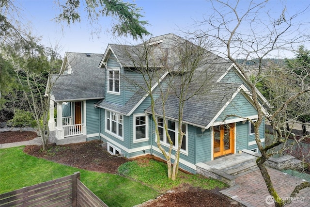 back of house featuring a yard and roof with shingles