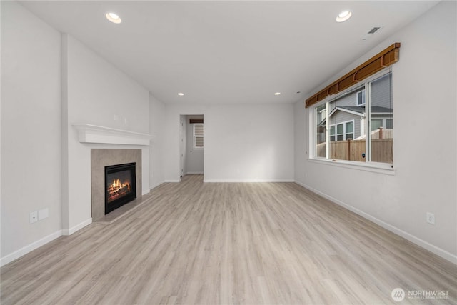 unfurnished living room featuring recessed lighting, light wood-style flooring, and a fireplace