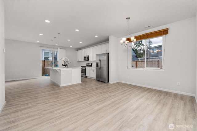 kitchen with visible vents, open floor plan, appliances with stainless steel finishes, and light wood-type flooring