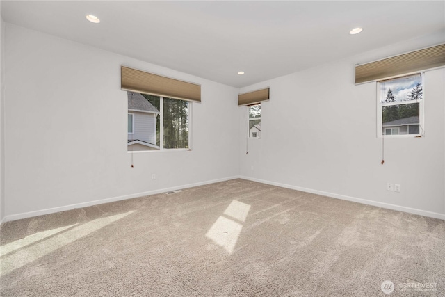 empty room featuring recessed lighting, baseboards, and carpet