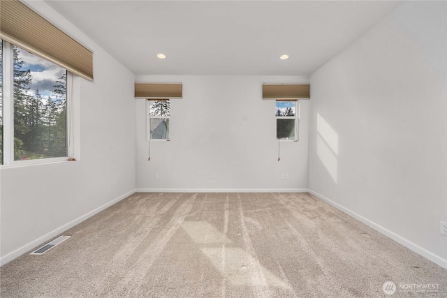 carpeted spare room featuring recessed lighting, visible vents, and baseboards