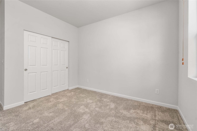 unfurnished bedroom featuring carpet, baseboards, and a closet