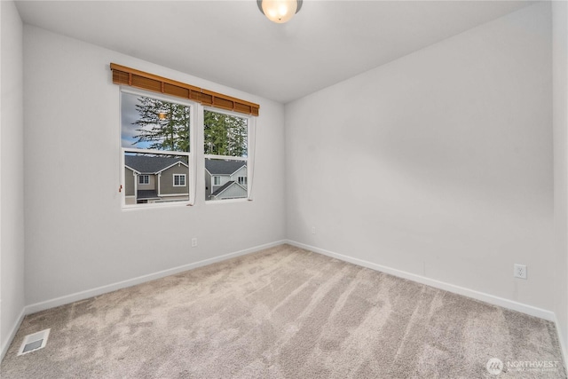 empty room with visible vents, baseboards, and carpet