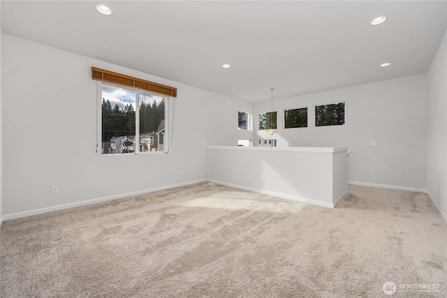 empty room featuring recessed lighting, baseboards, and light colored carpet