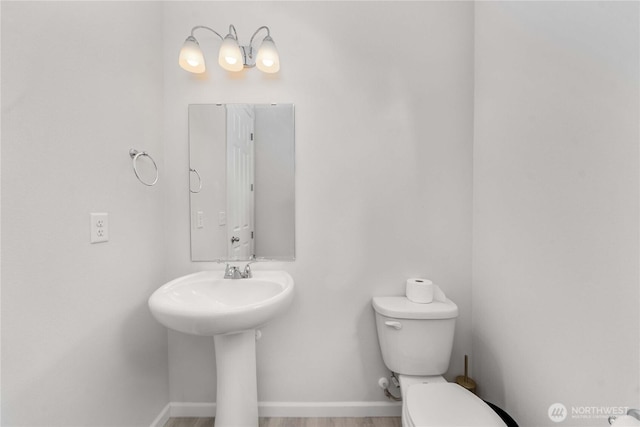 bathroom with toilet and baseboards