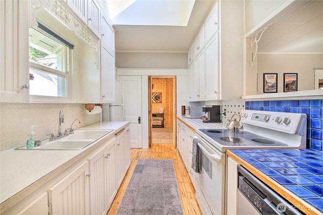 kitchen with a sink, dishwashing machine, white cabinetry, and white electric stove