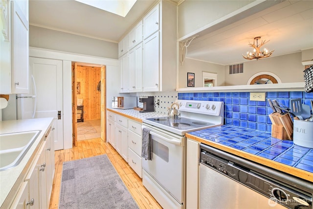 kitchen with stainless steel dishwasher, electric range, visible vents, and white cabinets