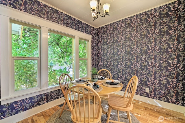 dining area featuring a chandelier, plenty of natural light, wallpapered walls, and hardwood / wood-style flooring