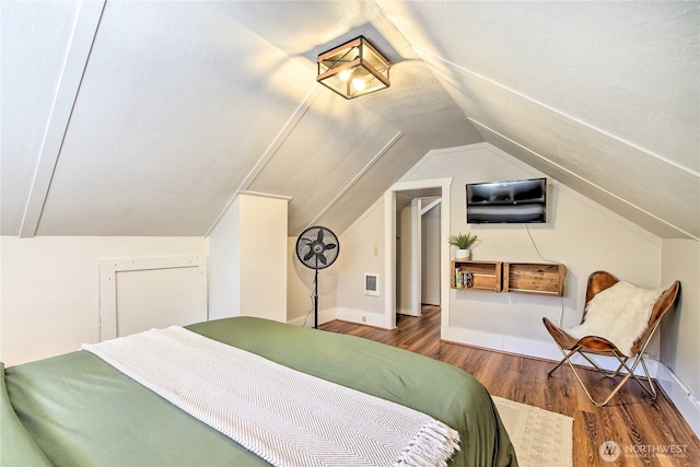 bedroom with lofted ceiling, wood finished floors, and baseboards