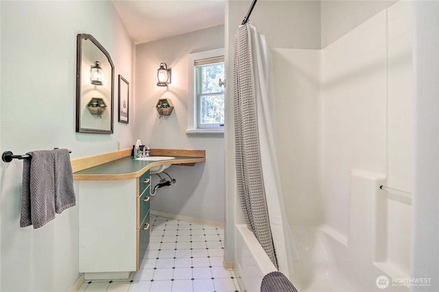 full bathroom with tile patterned floors, baseboards, shower / bath combo, and vanity