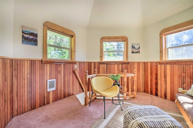 sitting room featuring wainscoting, wood walls, carpet, and a healthy amount of sunlight