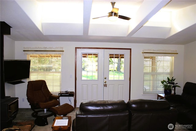 living room with a wood stove, a ceiling fan, and french doors