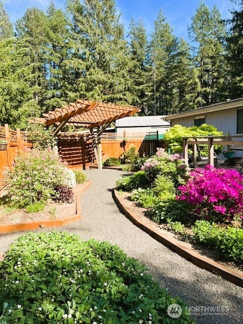 view of home's community with fence and a pergola