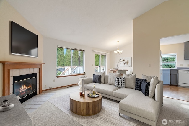 living room with an inviting chandelier, vaulted ceiling, a fireplace, and light colored carpet