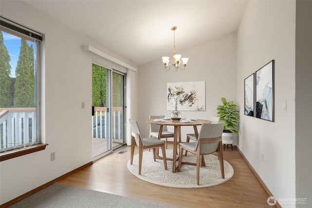 dining room with a wealth of natural light, baseboards, and a notable chandelier