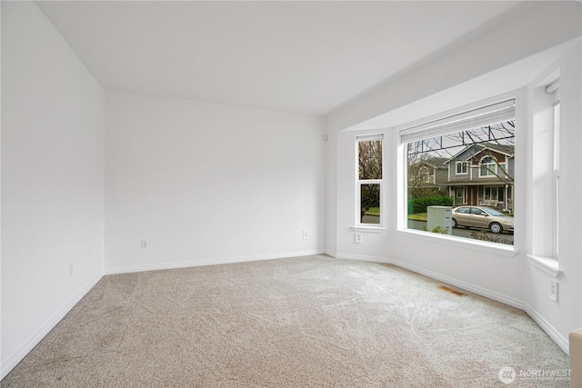 unfurnished room with visible vents, baseboards, and carpet floors