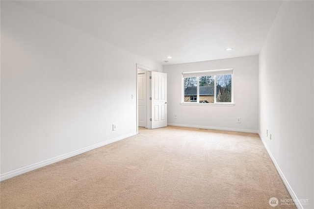 empty room featuring recessed lighting, baseboards, and light colored carpet