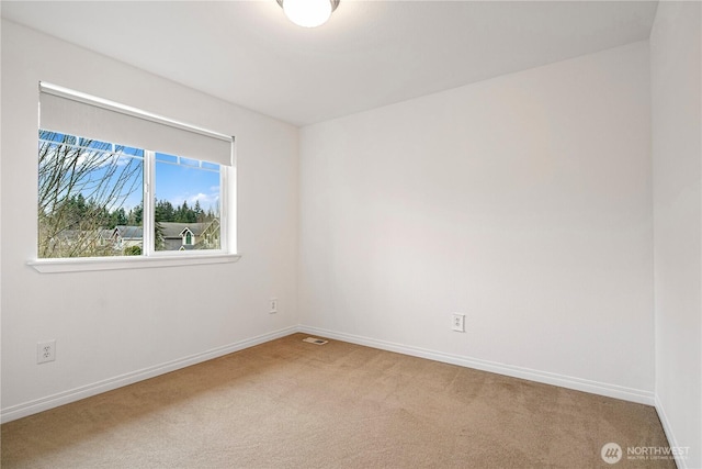 empty room featuring visible vents, baseboards, and carpet flooring