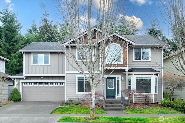 view of front of property with board and batten siding, an attached garage, driveway, and roof with shingles