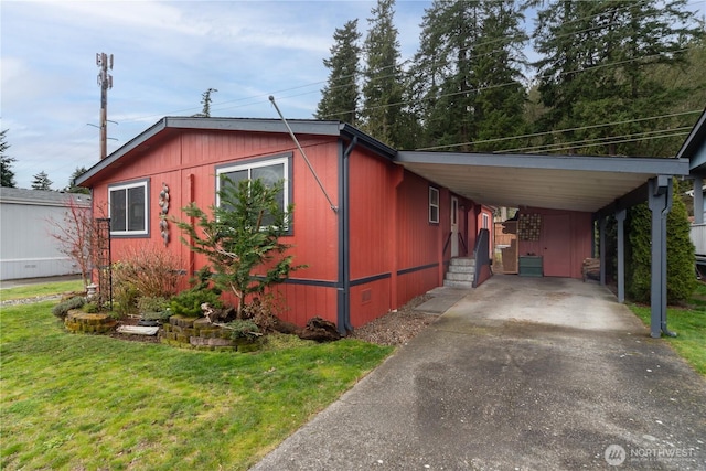 view of home's exterior featuring a yard, an attached carport, and driveway