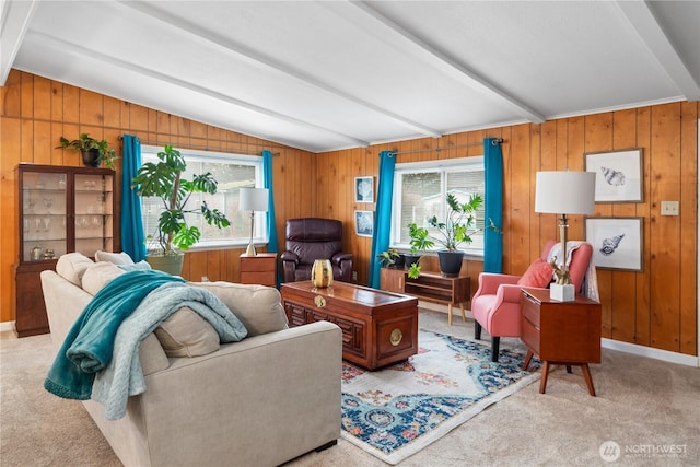 living area with lofted ceiling with beams, carpet flooring, a healthy amount of sunlight, and wood walls