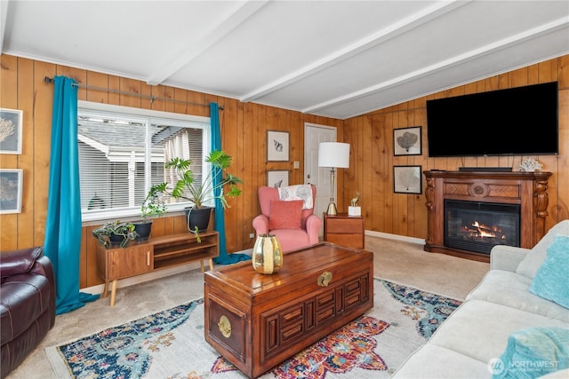 living room with a glass covered fireplace, wood walls, lofted ceiling with beams, and carpet floors