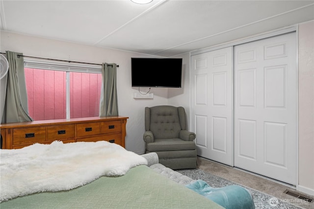 bedroom with visible vents, a closet, and carpet floors