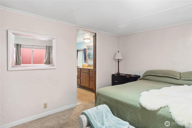 bedroom with a sink, light colored carpet, baseboards, and connected bathroom