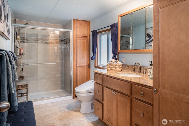 bathroom with toilet, a stall shower, and vanity