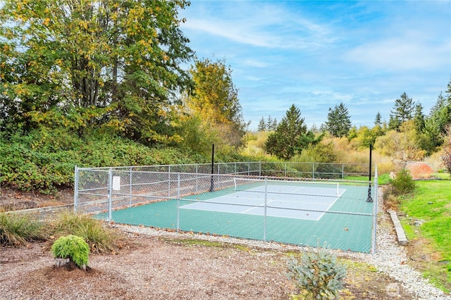 view of home's community with a tennis court and fence