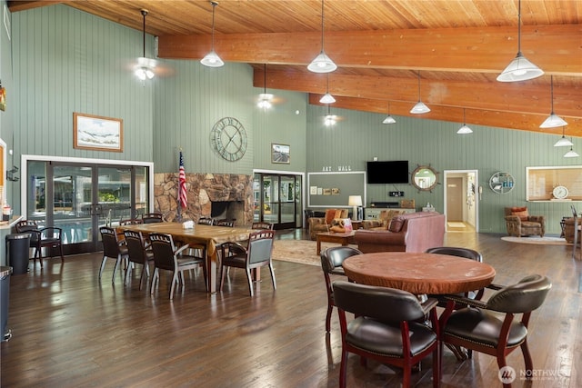 dining room with beamed ceiling, hardwood / wood-style floors, a fireplace, and french doors